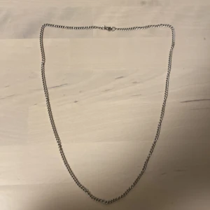 Rostfrittstål kedja ca 50-60 cm - Säljer ett stilrent silverfärgat kedjehalsband med en klassisk karbinhake. Perfekt för att komplettera din look med en enkel men elegant touch.
