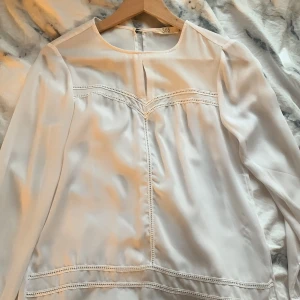 Vit blus från 365 - En jätte fin blus, lite genomskinligt men man kan ha linne under! Fina detaljer. Används inte. Tunt men bra material