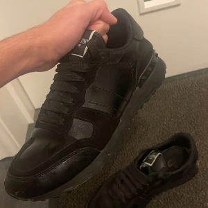 Svarta rock rummets från Valentino - Snygga svarta sneakers från Valentino med coola nitar på sulan. Skorna har en stilren design med snörning och är tillverkade i skinn och mocka. Pris går att diskutera haft skorna i någon vecka 