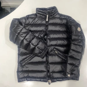 Dam dunjacka från Moncler - Säljer en snygg svart dunjacka från Moncler. Jackan har en quiltad design med dragkedja framtill och två fickor med dragkedjor. Perfekt för kyliga dagar med sin varma och stilrena look.