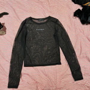 Svart meshtröja från FB Sister - Säljer en svart meshtröja från FB Sister med texten 'Black Mood' på bröstet. Tröjan har långa ärmar och är perfekt för lager-på-lager-stil. Supercool och trendig! 🖤