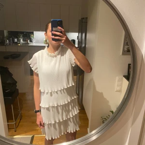 Vit studentklänning från YAS - Säljer en söt vit studentklänning från YAS med volanger och korta ärmar. Perfekt för sommarens alla tillfällen. Säljer för att den är för stor för mig. 