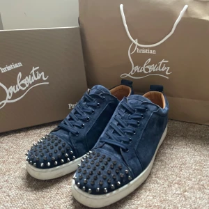 Christian Louboutin mörkblå louis sneakers - Jättesnygga navy Christian Louboutin (Louis n luck flat veau velours) Sneakers, just denna Christian Louboutin modellen är väldigt sällsynt, hittar inte ett ända par i den här storleken. Nypris är 9000, mitt pris 4999 men kan även gå ner i pris för rätta köparen. Nästan allt og följer med (ses på sista bilden) 3 spikar saknas på vänster skon men det går att köpa nya spikar. Storleken är 46.5 men CL har små storlekar så passar mig med 45.5 perfekt. Det var allt för mig❤️🍾