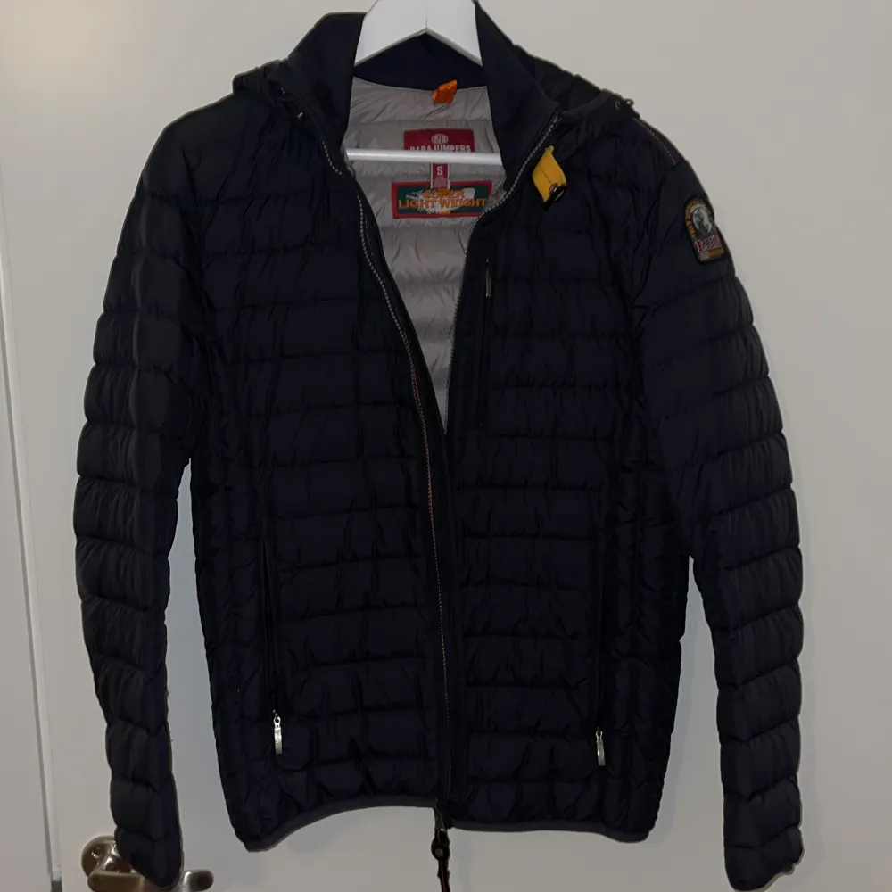 Snygg quiltad jacka från Parajumpers med huva och dragkedja. Litet hål vid ärmen. . Takit.