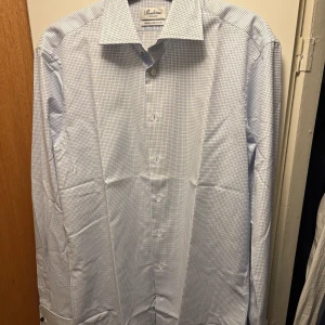 Rutig skjorta från Stenströms - Snygg rutig skjorta från Stenströms i vitt och blått. Skjortan har klassisk krage, twofolded och med plats för manschettknappar. Tillverkad i mjuk bomull och har en fitted passform. Strl 38, använd 1 gå g