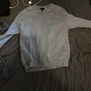 Grå sweatshirt från H&M, storlek XS - Enkel och stilren grå sweatshirt från H&M i storlek XS I relaxed fit. Tröjan har rund halsringning, ribbade muddar vid ärmslut och nederkant samt långärmad passform. Perfekt för en chill och avslappnad look.