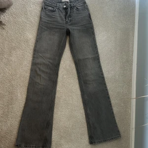 Grå bootcut jeans från Perfect Jeans - Säljer ett par gråa bootcut jeans från gina tricot, Jeans i storlek 32. Jeansen har klassisk femficksdesign, normal passform och är tillverkade i mjukt denimtyg. Snygg tvättad grå färg som passar till allt och ger en cool vibe.