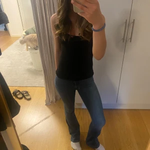 Blå bootcut jeans från Never Denim XS - Säljer ett par blå bootcut jeans från Never Denim i storlek XS. Jeansen har klassisk femficksdesign, normal passform och är tillverkade i en stretchig denimblandning av bomull, polyester och elastan. Snyggt utsvängda ben och mellanblå tvätt.