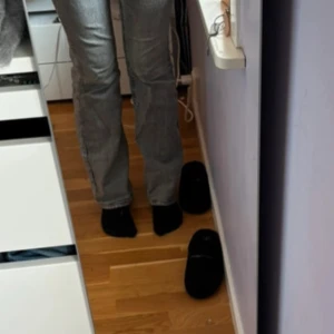 Grå bootcut jeans med fickdetaljer - Snygga grå jeans med bootcut-modell och fickor med lock och knapp bak.