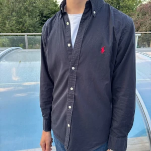 Svart skjorta från Polo Ralph Lauren - Svart Ralph Lauren skjorta 👔  Storlek S ✅  Super bra skick ✅  Nypris ca 1700kr💵 Pris går diskuteras 🤝 Hör av er vid frågor eller fler bilder:)