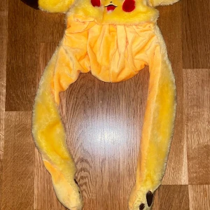 Pikachu mössa med LED-ljus - Supergullig gul Pikachu mössa med långa öron och inbyggda LED-lampor som lyser i olika färger. Mössan är mjuk och fluffig, perfekt för dig som vill sticka ut och sprida lite extra glädje. Passar både cosplay och chill dagar.