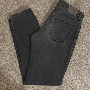 jeans från J.Lindeberg  - Snygga svarta jeans från J.Lindeberg i klassisk rak modell. Jeansen har fem fickor, bälteshällor och subtilt tvättad finish. Tillverkade i slitstarkt bomullstyg med en stilren look som passar till det mesta. Ny pris 1700kr mitt pris 299kr