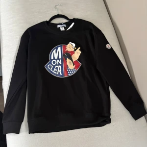 Moncler Tröja - Säljer denna goa moncler tröjan då den ej passar mig. Riktigt fet logga i mitten på tröjan samt en Badge på armen. Svårt och säga om denna är äkta eller inte men den e ruggigt snygg! Storlek :M: och passar om du är Runt 180+