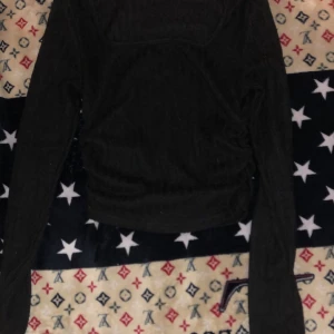 Svart ribbad långärmad topp - Säljer en svart långärmad topp med ribbad struktur. Toppen har en kroppsnära passform och är perfekt för att styla med jeans eller kjol. Enkel och stilren design som funkar till många olika looks.