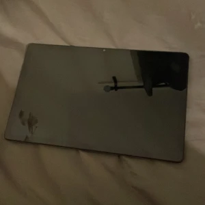 Surfplatta Lenovo  - Bilderna visar en Lenovo Tab M10 Plus surfplatta med tillhörande förpackning. Detta är ingen bok, utan en elektronisk enhet som kan användas för att läsa e-böcker, surfa på nätet och streama media. Perfekt för unga som vill ha en smidig och modern platta för studier eller underhållning. I och med att den är så ny och full pris var 2500kr så tycker jag att detta pris är rimligt och laddare ingår
