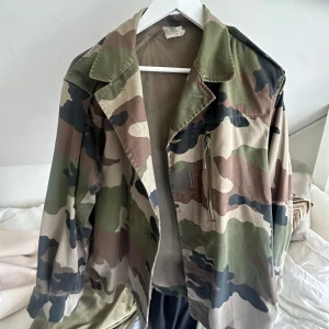 Armyjacket - Säljer en klassisk camouflage army jacka. Från Broadway and sons Jackan har krage, dragkedja och knappar framtill samt flera fickor. Perfekt för dig som gillar streetstyle eller vill ha en militärinspirerad look.