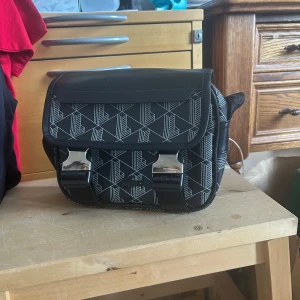 Lacoste axelväska  - Säljer denna snygga Lacoste axelväskan, väskan har varit sönder så handtaget revs sönder när jag var utomlands och samtidigt så har zip grejen ramlat av men annars är väskan i nyskick, handtaget är fixat det är lite skillnad från andra sidan men annars är den som vanlig, Kvitto finns digitalt. Pris kan diskuteras!! Tveka inte att skriva!!