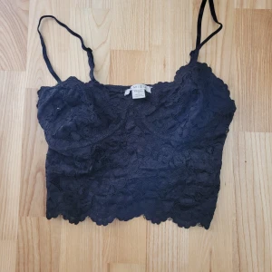 Linne - Svart croppat linne från Amisu med tunna justerbara axelband och vacker spets över hela toppen. 