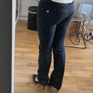 Svarta low waist jeans - Tvär snygga jeans som är väldigt låga, de har detaljer vid fickorna