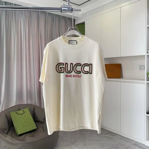 Vit GUCCI t-shirt med tryck - Snygg vit t-shirt från GUCCI med stort logotryck i rött, grönt och svart på bröstet. Klassisk rund hals och korta ärmar. Mjuk och skön bomullskvalitet som känns lyxig mot huden. Perfekt för dig som vill ha en clean och stilren look med designer vibe.