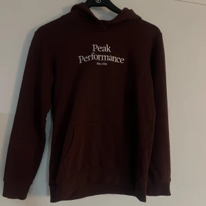PEAK PERFORMANCE  - En helt ny brun Peak Performance hoodie i nyskick. Endast använd 1 gång.