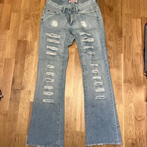 Bootcut jeans med slitningar  - Skit snygga ljusblåa jeans från Pash med coola slitningar både fram och bak. Köpte för liten storlek så dom är helt oanvända! Pris kan såklart diskuteras 💞