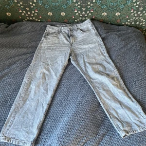 Grå jeans från Bershka - Säljer ett par grå jeans från Bershka i en avslappnad passform. De har en klassisk femficksdesign och är tillverkade i ett bekvämt denimtyg. Perfekta för en casual look.