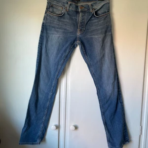 Blå jeans från Nudie Jeans - Säljer ett par  blå jeans från Nudie Jeans i storlek 34 x 34. De har en normal passform och är tillverkade i slitstarkt denim. Skriv vid funderingar eller frågor!