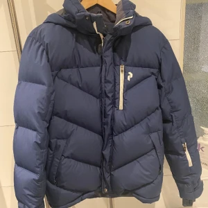 Peak vinterjacka - Marinblå vinterjacka utan luva.  Använd få gånger.  Även bra som skidjacka.  Peak performance. Stl 170.obs luvan ingår inte