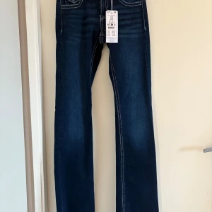 Helt nya Blå chunky flare jeans från Gina Tricot - Snygga blå chunky flare jeans från Gina Tricot med låg midja. De har en klassisk femficksdesign och kontrasterande sömmar som ger en cool look. Från Gina Young men passar mig som vanligtvis har xs, är i tall modellen. Mått: midja: 70 cm, innerben: 83