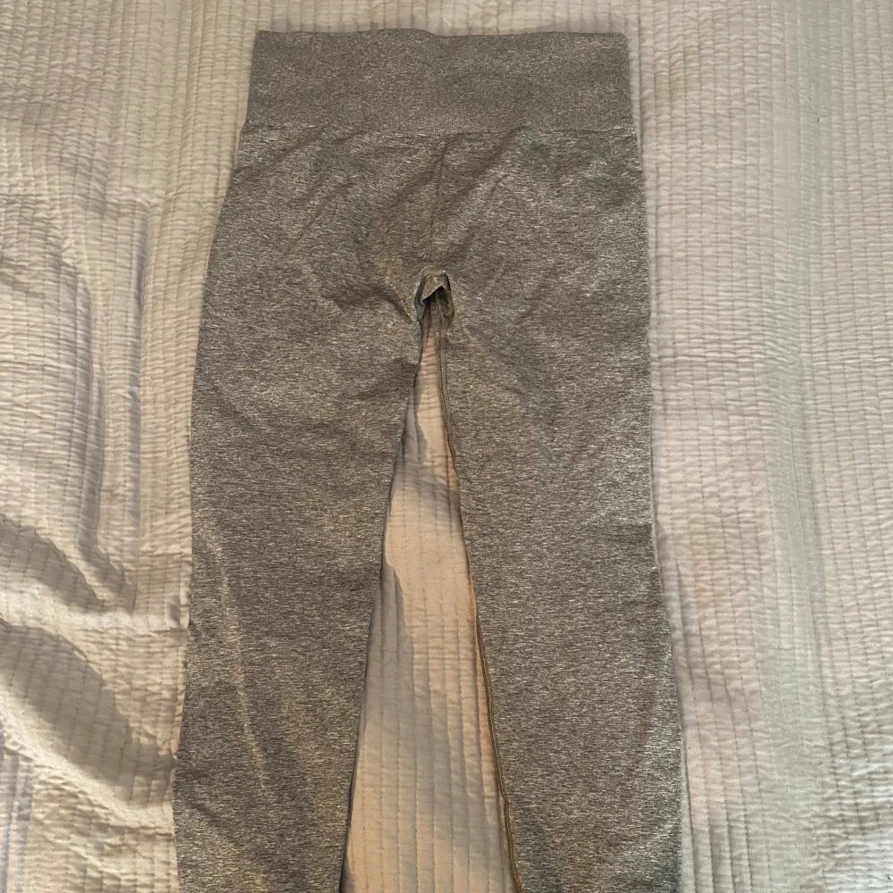 Snygga grå leggings från Gymshark med hög midja och en bekväm passform. Perfekta för träning eller en avslappnad dag. Materialet är stretchigt och följsamt.. Farkut & Housut.