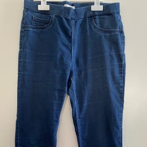 Mörkblå jeansbyxor - Snygga mörkblå jeansbyxor med en klassisk design. Byxorna har en elastisk midja och två fickor fram och bak. Perfekta för en avslappnad stil.