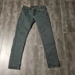 Grå dondup george jeans  - Säljer ett par grå dondup george jeans. De har en klassisk femficksdesign och en rak passform. Perfekta för en avslappnad stil. Midjan är normalhög och de har en knapp- och dragkedjestängning. Inga defekter. Lite konstigt material.
