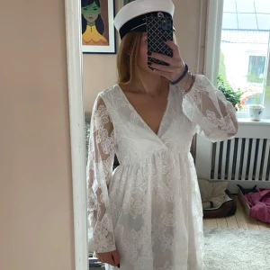 Vit spetsklänning med v-ringning - Säljer nu min fina student klänning. Två lager av tyg förutom på ärmarna. Fina blommönster i spets. Använt en gång så inga defekter. Köpte förra året från Gina för 699kr. Säljer för 400kr 🎓