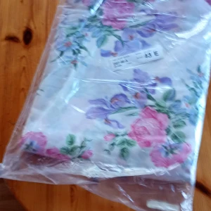 Blommig Gardintyg 10 meters bunt med rosa och lila blommor - Säljer en vackert Gardintyg 10 meters bunt blommigt med ett blommigt mönster i rosa och lila nyanser på en vit bakgrund. Perfekt för dig som älskar färgglada och livfulla mönster. 