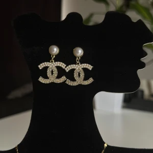 Guldiga örhängen med pärlor - Eleganta örhängen i guld med glittriga detaljer och pärlor. Perfekta för att ge en lyxig touch till din outfit.