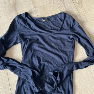 Mörkblå långärmad topp från Gina Tricot - Säljer en mörkblå långärmad topp från Gina Tricot. Perfekt för lager-på-lager eller som den är. Enkel och stilren design som passar till det mesta.det finns ett litet håll längs ned på tröjan men inget man tänker på 🩷🩷
