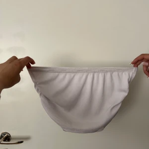 Toppar  - Säljer två bikinibyxor i ribbat material, en i ljuslila och en i svart. Båda har en enkel och klassisk form med normal passning. Perfekta för sommaren och strandhäng!