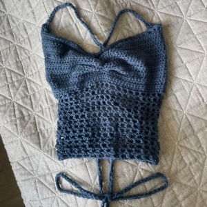 Handvirkad topp - Säljer en handvirkad vit topp jag själv gjort. Den har smala axelband och snörning i ryggen och tack vare den reglerbara knytningen passar den många olika storlekar! 