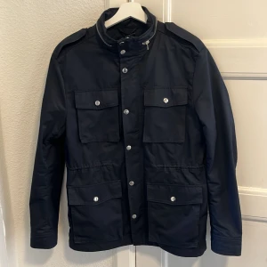 Navy field jacket från H&M - Säljer en marinblå field jacket från H&M som tyvärr blivit för liten. Vid minsta fråga är det bara att höra av sig!