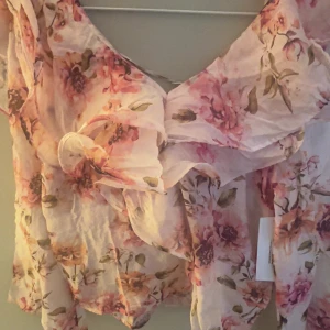 Blommig volangblus från Bubbleroom - Säljer en romantisk blommig blus från Bubbleroom i storlek S. Blusen har volangdetaljer, v-ringning och knytning framtill. Tunt, luftigt material i rosa och beige toner med blommönster. Perfekt för vår och sommar! Den är i storlek s och helt oanvänd med lapparna kvar då jag råka beställa 2, säljer den 100 kr billigare då den kostar 600 egentligen 💞