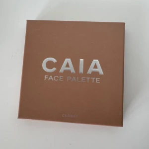 CAIA Face Palette Classy - Säljer en CAIA Face Palette i färgen Classy med fyra olika puder: contour, blush, bronzer och highlighter. Paletten har en inbyggd spegel och kommer i en snygg brun förpackning. Perfekt för att skapa en fräsch och definierad look. Enbart testad😊bara råkat nudda den med nageln när jag skulle stänga. 