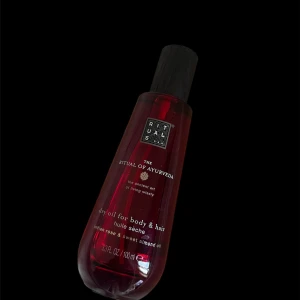The Ritual of Ayurveda dry oil - Torr olja för kropp och hår från Rituals, The Ritual of Ayurveda. Kommer i en mörkröd glasflaska med svart lock, nästan som ny. Men använd 1-2 gg