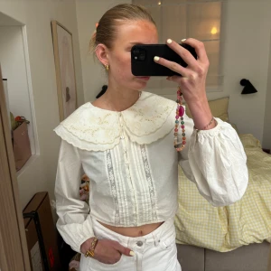 Ganni inspirerad blus - Supersöt vit blus med stor broderad krage och knappar framtill. Croppad med fina detaljer. Perfekt till sommar🌸