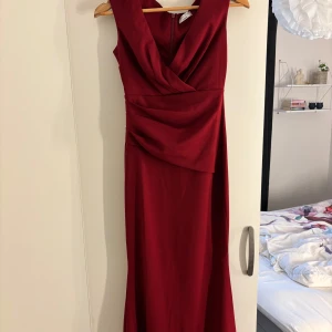 Vinröd långklänning - Jättefin vinröd långklänning från Bubbleroom, goddiva London med omlott-detalj upptill och draperad midja. Endast använd en kväll, den har inga defekter alls! Perfekt till bal eller andra tillfällen🌺