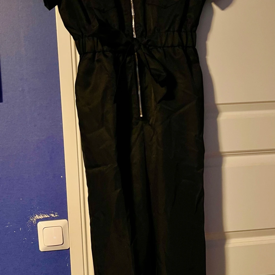 Svart lång jumpsuit med dragkedja och knytband