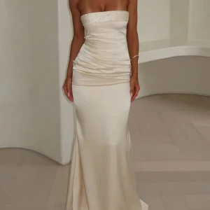 Balklänning  - En fin champagne färgad balklänning med knytning i ryggen och små diamanter vid brösten. Är sååå fin säljer bara för att jag hittade en annan klänning. Köpt för 1300kr. Aldrig använts. 