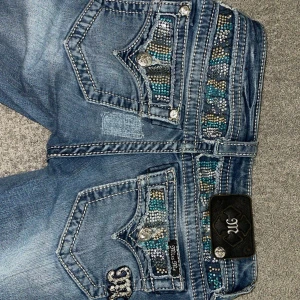 Miss me bootcut Jeans - Säljer ett par Lågmidjade miss me jeans💗midjemått: 35-36cm, innerbenslängd 77cm. Jag är ungefär 161 som referens💗den enda defekten är att det var en liten fläck där bak och därav är det en liten tygbit där bak💗💗