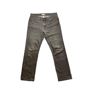 Redwood Jeans - Säljer ett par gråa jeans från Redwood Jeans i rak modell. Klassisk femficksdesign med snygga kontrastsömmar och läderpatch bak i midjan. Perfekta för dig som gillar en enkel och stilren look. 