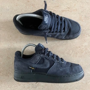 Nike Air Force 1 Low ’07 Cordura - (Og pris. 1600 )  Säljer ett par mörkblå (ser nästan svarta ut)  Nike Air Force 1 med Cordura. Skorna har ovandel i mocka och textil, svart platt sula. Perfekta för dig som vill ha stilrena sneakers. Priset kan diskuteras.